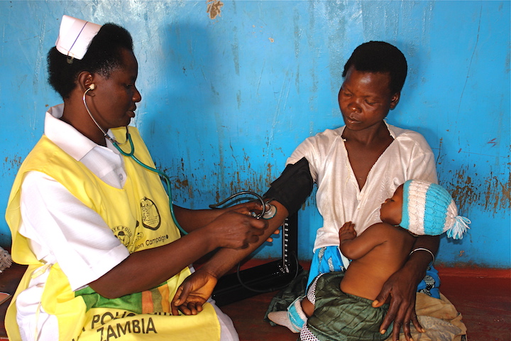 Zambian nurse checks mother's blood pressure